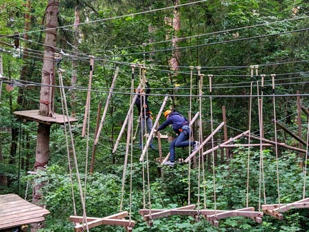 Gemeinschaftlich hangelt sich das PROXORA Team durch den Hochseilklettergarten.